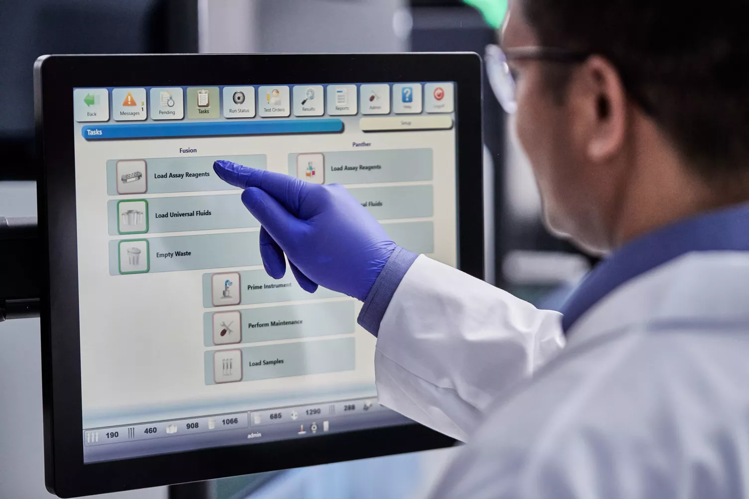 Tecnico di laboratorio che preme pulsanti su un monitor