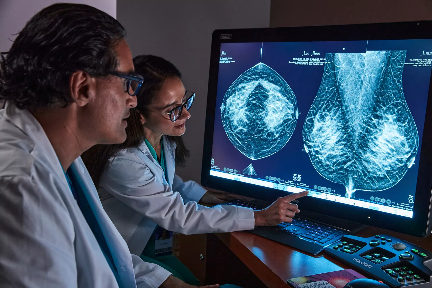 Operatore sanitario che indica un’immagine mammografica su un monitor