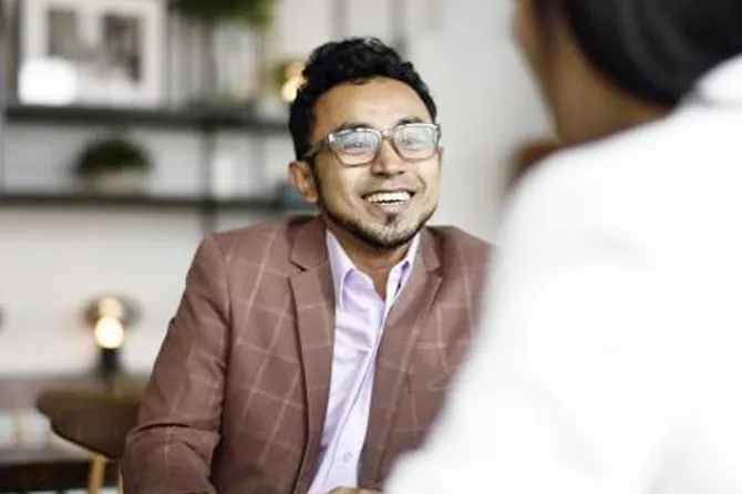 Uomo che sorride e parla con una donna in un ufficio
