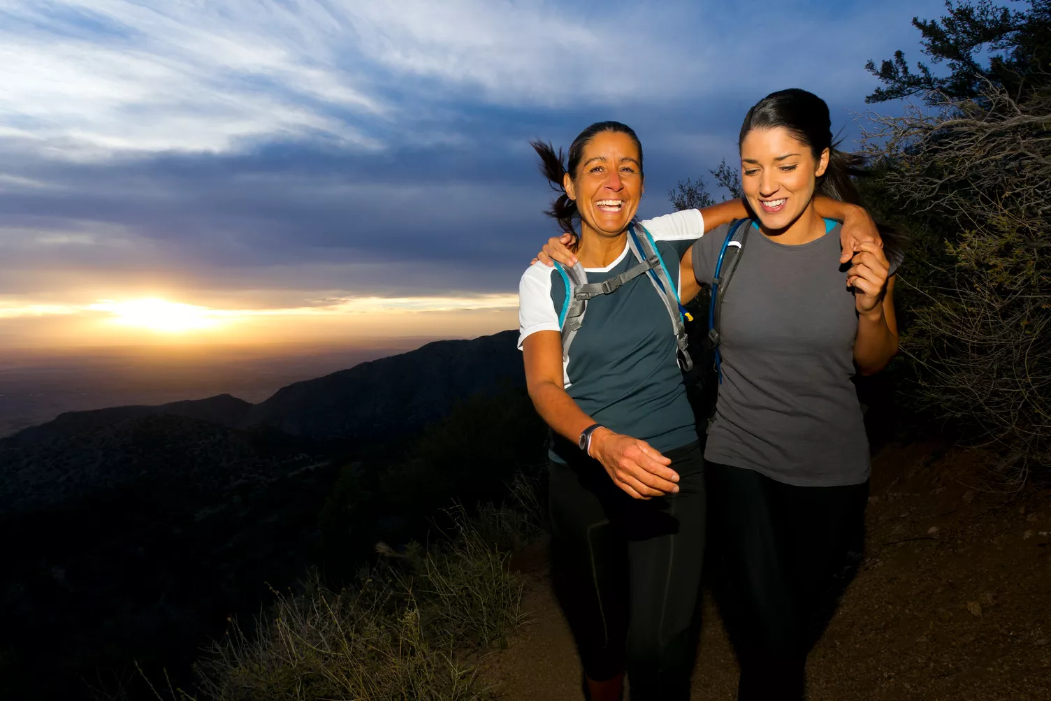 Due donne su un sentiero in collina al tramonto