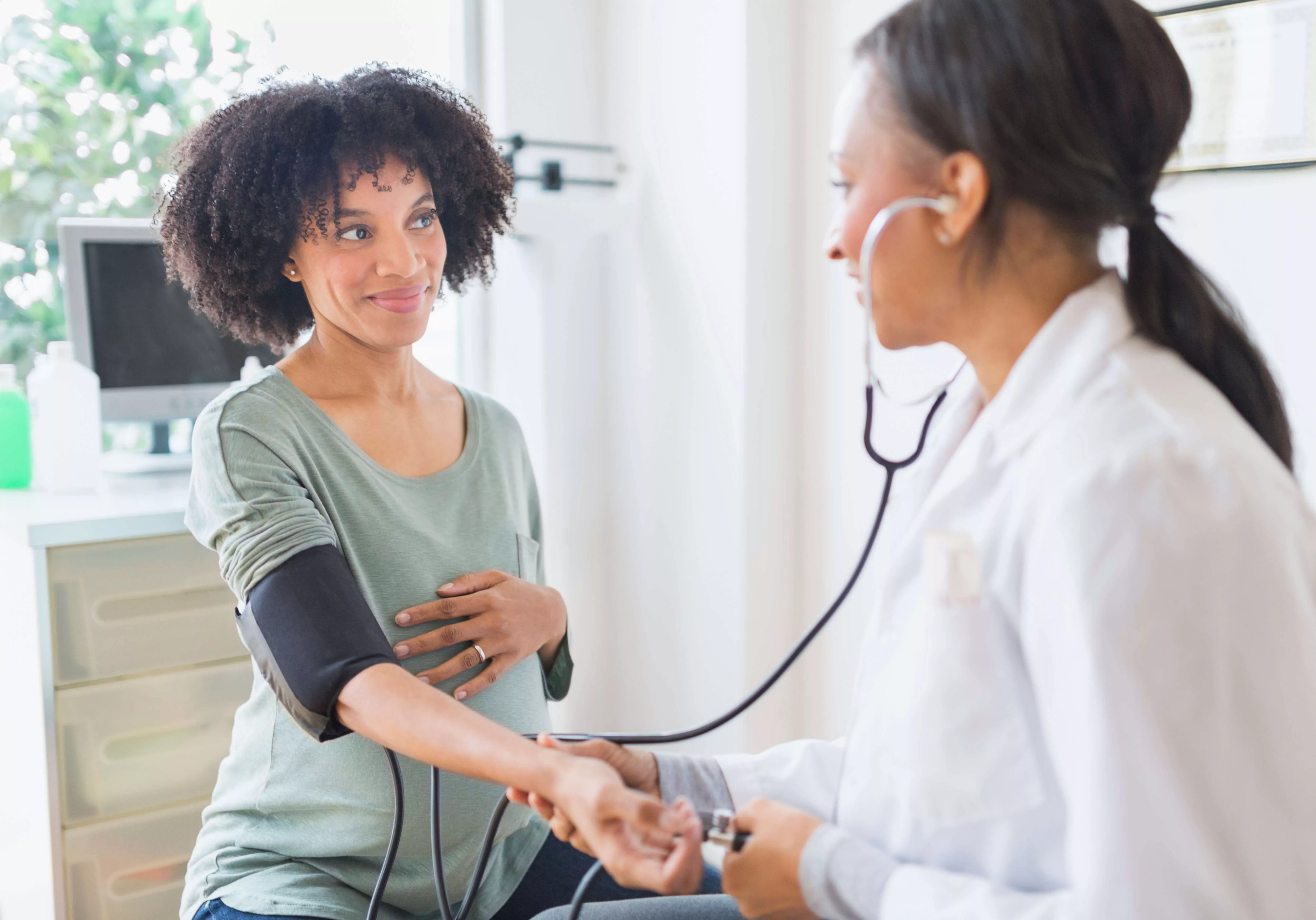 Medico che utilizza lo stetoscopio sul braccio di una donna.