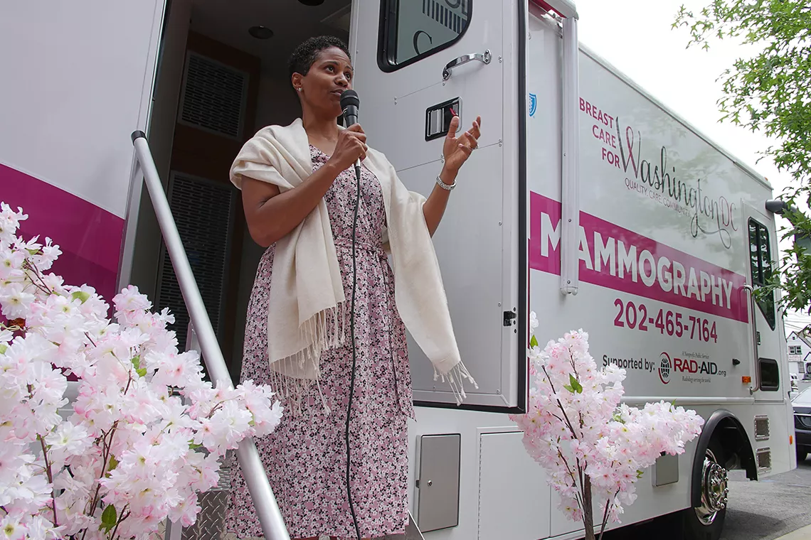 Donna che parla al microfono davanti a un autobus di MobileMammo