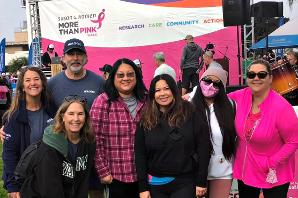 Foto di gruppo di uomini e donne sorridenti all'evento Race for the Cure di Susan G. Komen