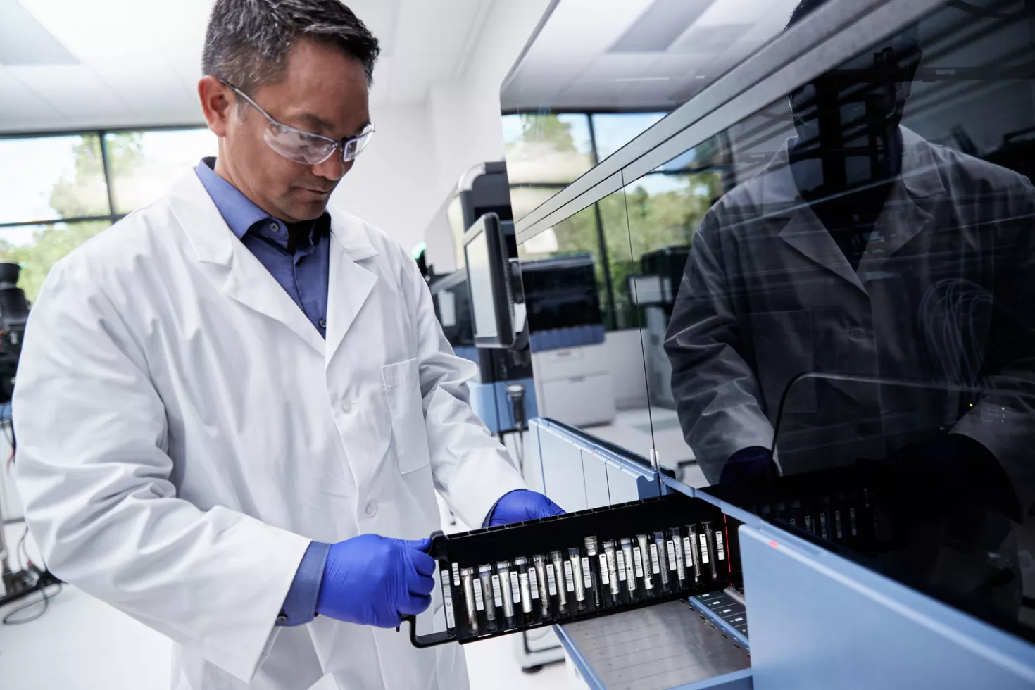 Tecnico di laboratorio che inserisce provette in un'apparecchiatura